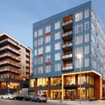 Avalon Estera 8 exterior shot during the evening highlighting the custom balconies and railings