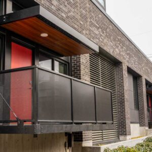 Metal railings with sun shade and balconies on first level apartments