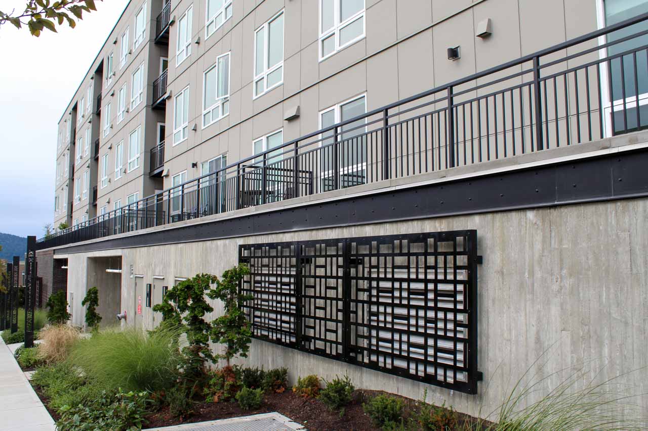 Vertical picket railing on a multifamily complex along with custom metal enclosures