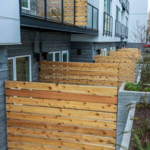 Frameless fences separating ground floor units of a complex